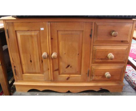 A modern pine sideboard with two cupboard doors, internal shelf and three drawers
