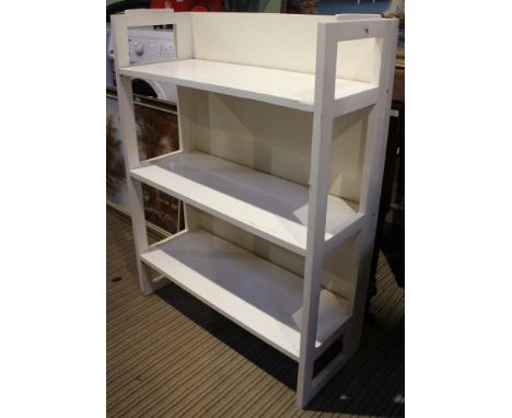 A collapsible white three shelf bookcase