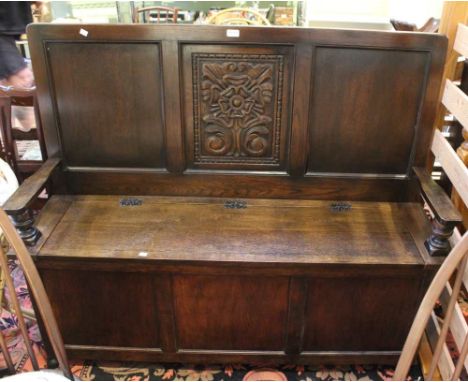 A reproduction carved monks bench with lift up seat