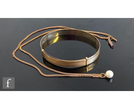 A 9ct hallmarked stiff bangle with engine turned decoration, weight 9g, Birmingham 1935, with a 9ct curb chain with single pe