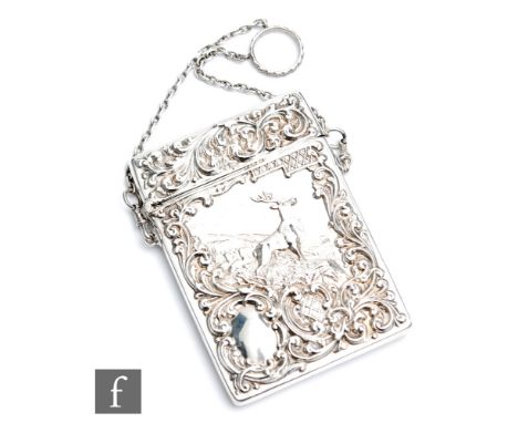 An early 20th Century hallmarked silver rectangular card case embossed with the study of a standing stag in a landscape setti