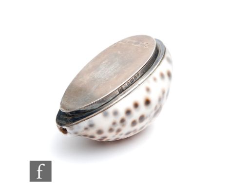 A George III hallmarked silver mounted cowrie shell snuff box with engraved initials to hinged cover, length 8cm, London 1829