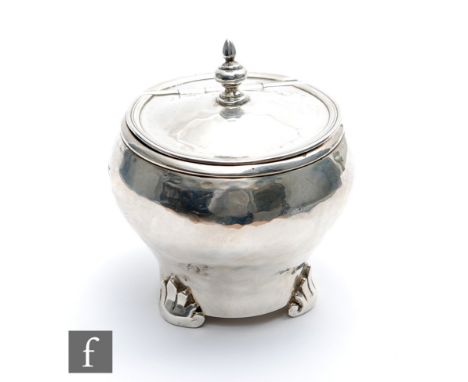 An Arts and Crafts hallmarked silver tea caddy with spot hammered decoration and raised on three feet, weight 3.5oz, London 1