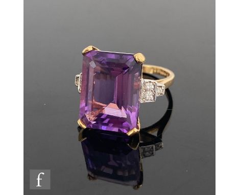 An 18ct hallmarked emerald cut amethyst ring, claw set stone, length 16mm, detailed with three brilliant cut diamonds to each