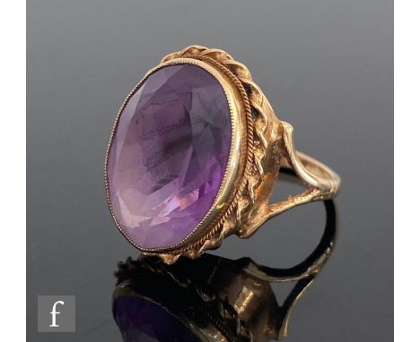 A 9ct hallmarked amethyst single stone ring, collar set stone, length 18mm, to a rope twist border and split shoulders, weigh
