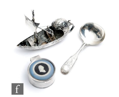 A Dutch silver toy modelled as a man in a sailing boat, with a Victorian caddy spoon and a modern circular box with a Wedgwoo