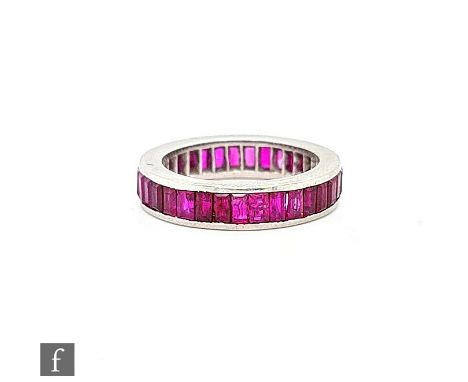 A French platinum full eternity ring with baguette cut channel set rubies, weight 6.9g, ring size K. 