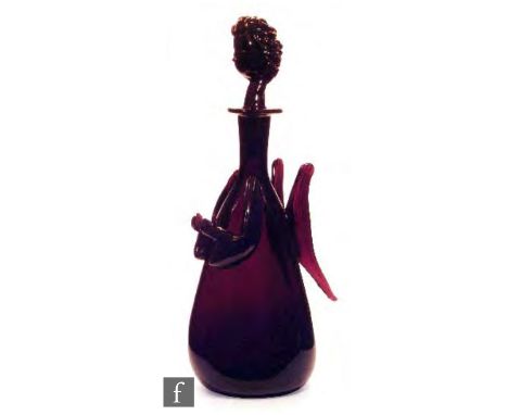 A 20th Century glass decanter formed as a stylised angel, all in a deep amethyst, the triform body with applied wings and arm