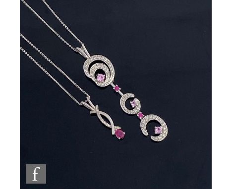 A modern 9ct white gold diamond, ruby and pink sapphire pendant, diamond set scrolls highlighted with five alternating rubies