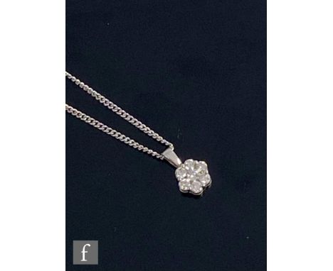 A contemporary 9ct hallmarked white gold diamond cluster pendant, seven brilliant cut stones claw set and suspended from 9ct 