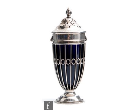 A hallmarked silver sugar castor, circular spread foot below strut and ring pierced body encompassing blue glass liner and ba