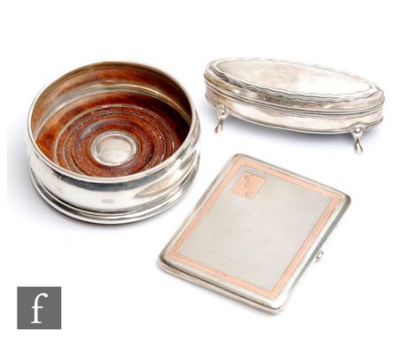 Three hallmarked silver items to include a bottle coaster, an engine turned cigarette case with gold inlay and an elongated o