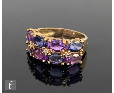 A 9ct hallmarked amethyst, iolite and diamond ring, alternating rows of oval amethyst and iolite detailed with three diamonds