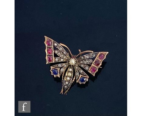 An early 20th Century gold and silver brooch modelled as a butterfly and set with ruby, diamond, sapphire wings and split pea