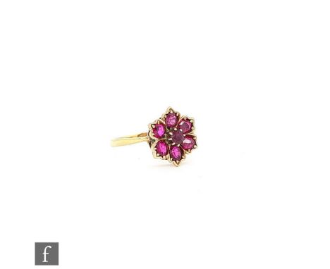 A mid 20th Century ruby cluster ring seven stones to a stylised flower head setting and knife edged shoulders, weight 3.4g, r