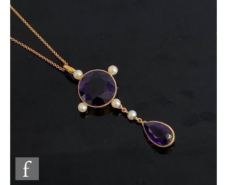 An early 20th Century 9ct amethyst and seed pearl pendant, central circular amethyst, diameter 14mm, with four pearls to bord