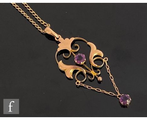 An Edwardian 9ct rose gold open work pendant set with two amethysts and suspended from a later 9ct curb chain, total weight 4