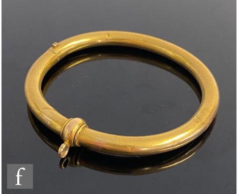An early 20th Century hinged bangle of plain tubular form with single swivel ring to centre, weight 12g, unmarked, S/D. 