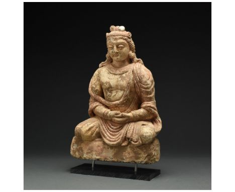 100 – 300 AD. Gandharan. A seated Buddha stucco buddha with flowing robes which fall off the shoulder, round face, thin lips,