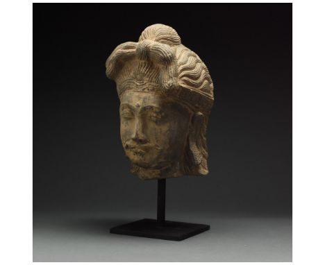 100 – 300 AD. Gandharan. This striking Gandharan schist head of a Bodhisattva is executed in a highly stylised manner, with a