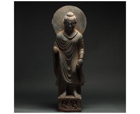 100 – 300 AD. Gandharan. A stunning schist figure of a standing buddha figure. This excellent figure is backed by a halo and 