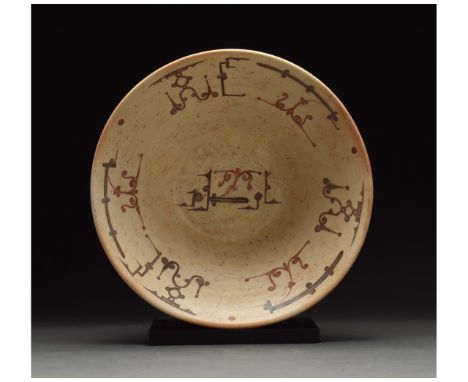 901 - 1000 AD or later. Medieval Islamic terracotta plate or bowl in a light brown fabric with a cream glazed interior. Brown