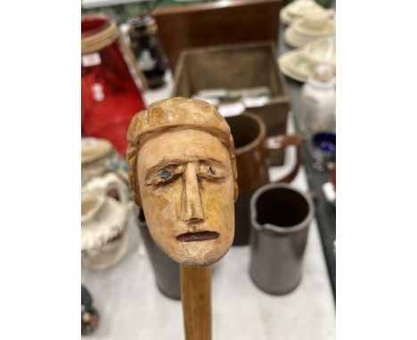 A CARVED WOODEN HEAD WALKING STICK 