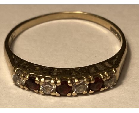 A 9 CARAT GOLD RING WITH THREE GARNETS AND FOUR CUBIC ZIRCONIAS IN LINE SIZE O/P 