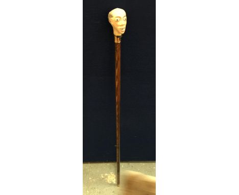 A VINTAGE WOODEN WALKING STICK WITH PAINTED FIGURAL HEAD DESIGN, SIGNED WH, WITH COPPER FERRULE 