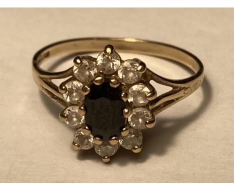 A 9 CARAT GOLD RING WITH CENTRE SAPPHIRE SURROUNDED BY CUBIC ZIRCONIAS SIZE M/N 