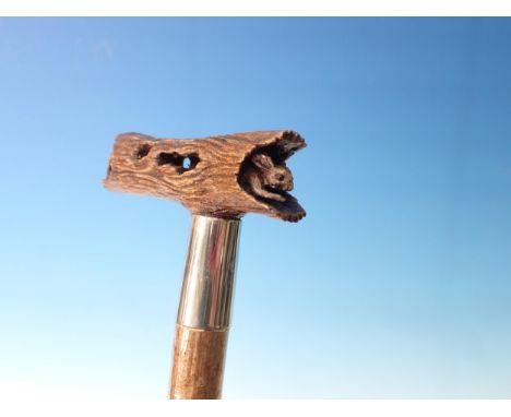 A hazel Walking Stick with carved wooden handle depicting a terrier chasing a rabbit through a hollow log 