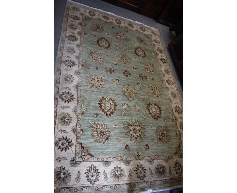 A Persian rug with all-over floral design on a light ground 100" x 60" approx 