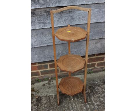 A light oak three-tier folding cake stand, and a light oak octagonal top occasional table, on turned supports, 22" dia x 16" 