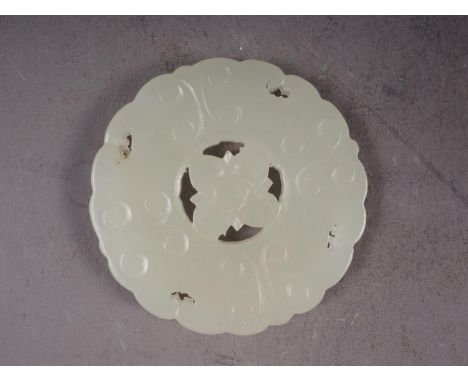 A Chinese carved pale jade pendant, 2 1/4" dia, with stand 