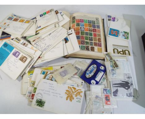 A stamp album containing a quantity of UK and Worldwide postage stamps, first day covers and a small quantity of loose stamps