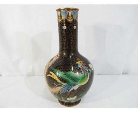 A Chinese cloisonne vase decorated with a phoenix and floral sprays on a black ground, blue counter enamel, approximately 23.