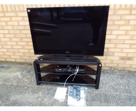 A Sony Bravia 40inch LCD flat screen television model #KDL-40NX703, a Panasonic DVD recorder and a television stand with glas