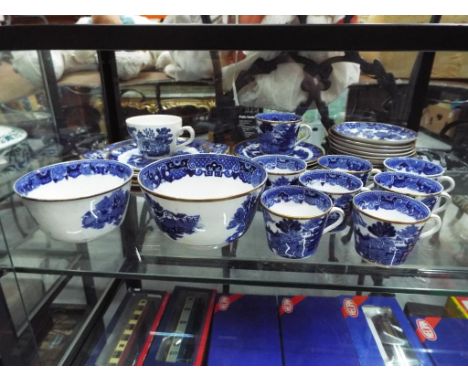 A quantity of blue and white tableware with gilded detail to include plates, cups, saucers and similar.