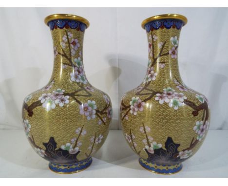 A pair of Chinese cloisonne vases decorated with prunus and flying birds, ruyi border to the neck, blue counter enamel, appro
