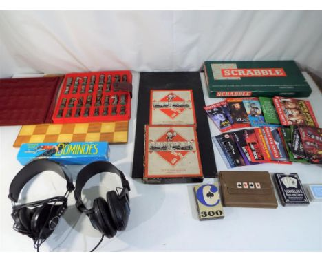 A mixed lot to include a chess board with cast metal pieces, vintage Monopoly game, Scrabble, dominoes and a pair of Ross hea