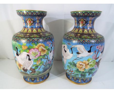 Am impressive pair of Chinese cloisonné enamelled vases, decorated with landscape scene, featuring prunus and other floral an
