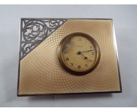 A George V hallmarked silver framed 8 day clock with Swiss movement, the frame, Birmingham assay 1928 with enamel and pierced