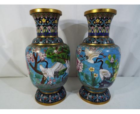 A large pair of Chinese cloisonne vases decorated with prunus and cranes, ruyi border to the neck and shoulder, blue counter 