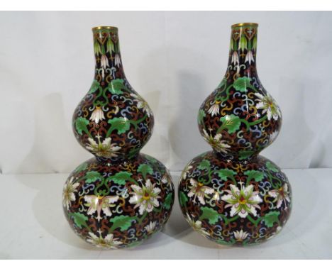 A pair of Chinese cloisonné enamelled double gourd form vases, each decorated with floral and foliate decoration on a black g