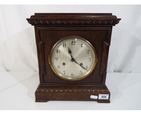 An oak case mantel clock, Arabic numerals to the dial with Junghens movement with pendulum. 