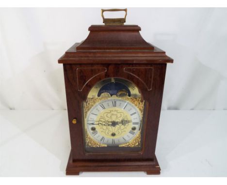 A wood cased Hermel mantel clock, brass dial, Roman numerals to a silvered chapter ring, moon phase to the arch Est £40 - £60
