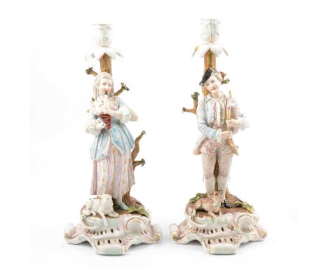 Pair of Meissen style figural candlesticks, with male bagpiper with dog companion, and female clarinet player with sheep comp