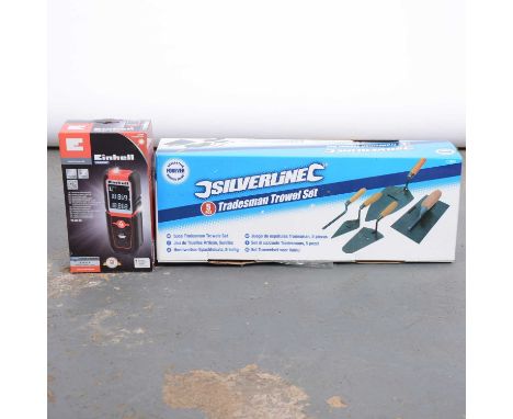 A box of various decorating tools including brushes and handtools.