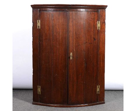 George III oak hanging corner cupboard, bow front with two doors, painted interior, width 72cm, depth 47cm, height 94cm .