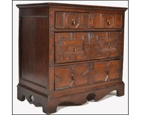 A 17th century Commonwealth oak block fronted chest of drawers. The bank of four drawers having carved geometric panels. Two 